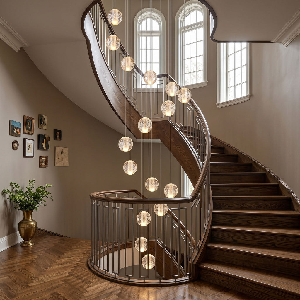 Clérachic crystal ball pendants dropping down the curve of a spiral staircase with a wooden handrail and arched windows.