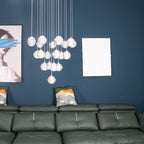 Closer view of the unlit Clérachic crystal ball cluster against a teal wall, with a framed print and cushions at the side.