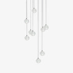 Clérachic crystal ball pendants in a group of clear spheres at staggered heights on thin cables, on white.