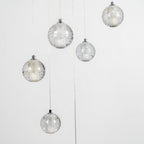 Closer view of unlit Clérachic crystal balls, showing the tiny trapped bubbles in the clear glass and the chrome caps on top.