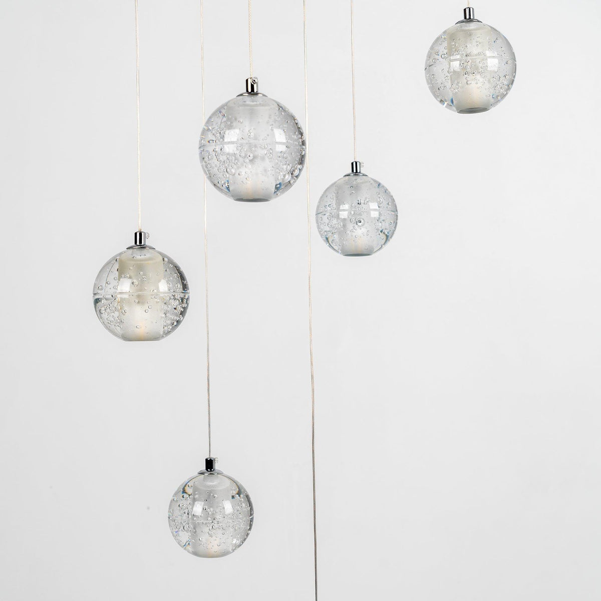 Closer view of unlit Clérachic crystal balls, showing the tiny trapped bubbles in the clear glass and the chrome caps on top.