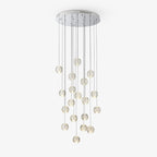 Clérachic crystal ball cluster on a round chrome ceiling plate with long thin cables, the spheres hanging at staggered heights on white.
