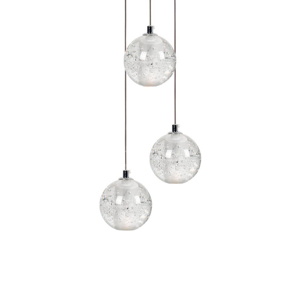Three Clérachic crystal ball pendants at different heights on thin cables, with trapped bubbles visible in each clear glass sphere.