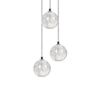 Three Clérachic crystal ball pendants at different heights on thin cables, with trapped bubbles visible in each clear glass sphere.