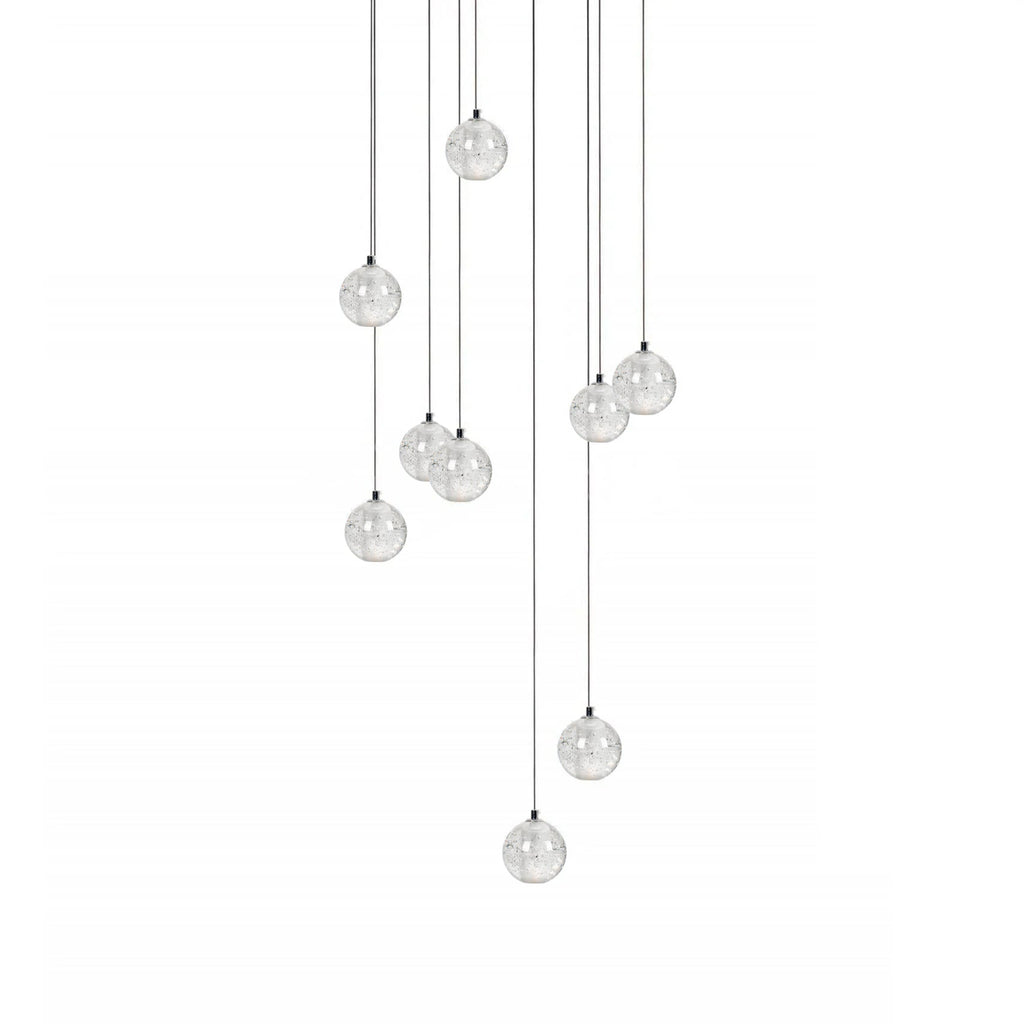 A loose group of Clérachic crystal ball pendants on thin cables of different lengths, hanging on a plain white backdrop.