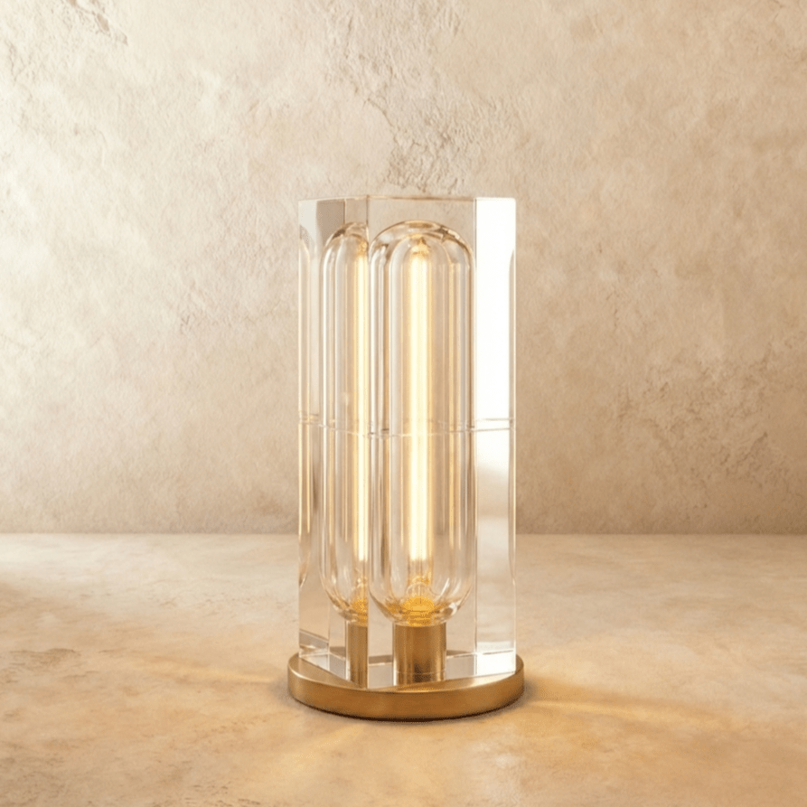 Clérachic larger tall crystal table lamp with a lit capsule bulb inside the clear block, on a round gold-tone base.