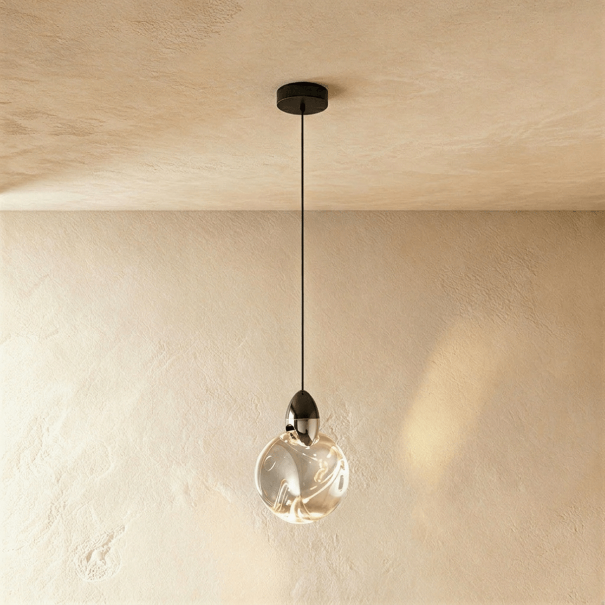 Clérachic round rippled clear glass pendant with a dark metal cap on a black cord and canopy, against a warm plaster wall.