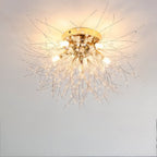 Clérachic gold crystal flush ceiling light seen close on a plain ceiling, bare bulbs lit among fine rods and clear beads.