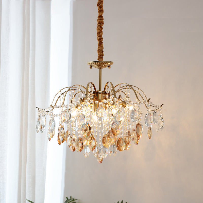 Amber and clear crystals catch the light on this Clérachic chandelier, hung beside sheer white curtains on a fabric-wrapped cord.