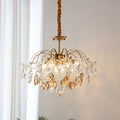 Amber and clear crystals catch the light on this Clérachic chandelier, hung beside sheer white curtains on a fabric-wrapped cord.
