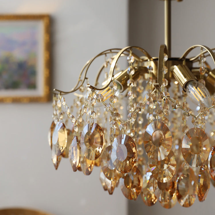 Close view of the large amber crystal drops and the exposed candle-style bulbs on this Clérachic chandelier.