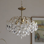Clear crystal version of this Clérachic chandelier hung from a chain, with a framed abstract painting behind it.