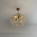 Clear crystals on a Clérachic chandelier fitted close to a pale ceiling, with a plain cornice line running behind it.