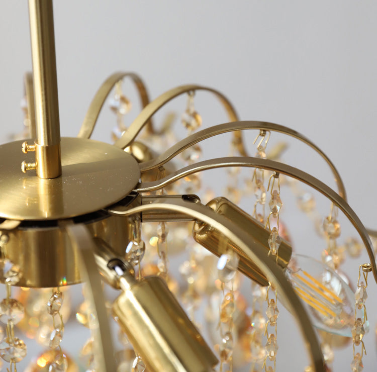 Close view of the brass canopy, curved arms and candle-style bulb holders on this Clérachic chandelier.
