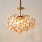 Close-up of the glowing amber crystals and bulbs on this Clérachic chandelier, hung from a fabric-wrapped cord on a warm backdrop.