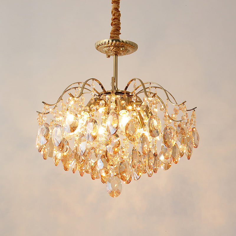 Close-up of the glowing amber crystals and bulbs on this Clérachic chandelier, hung from a fabric-wrapped cord on a warm backdrop.