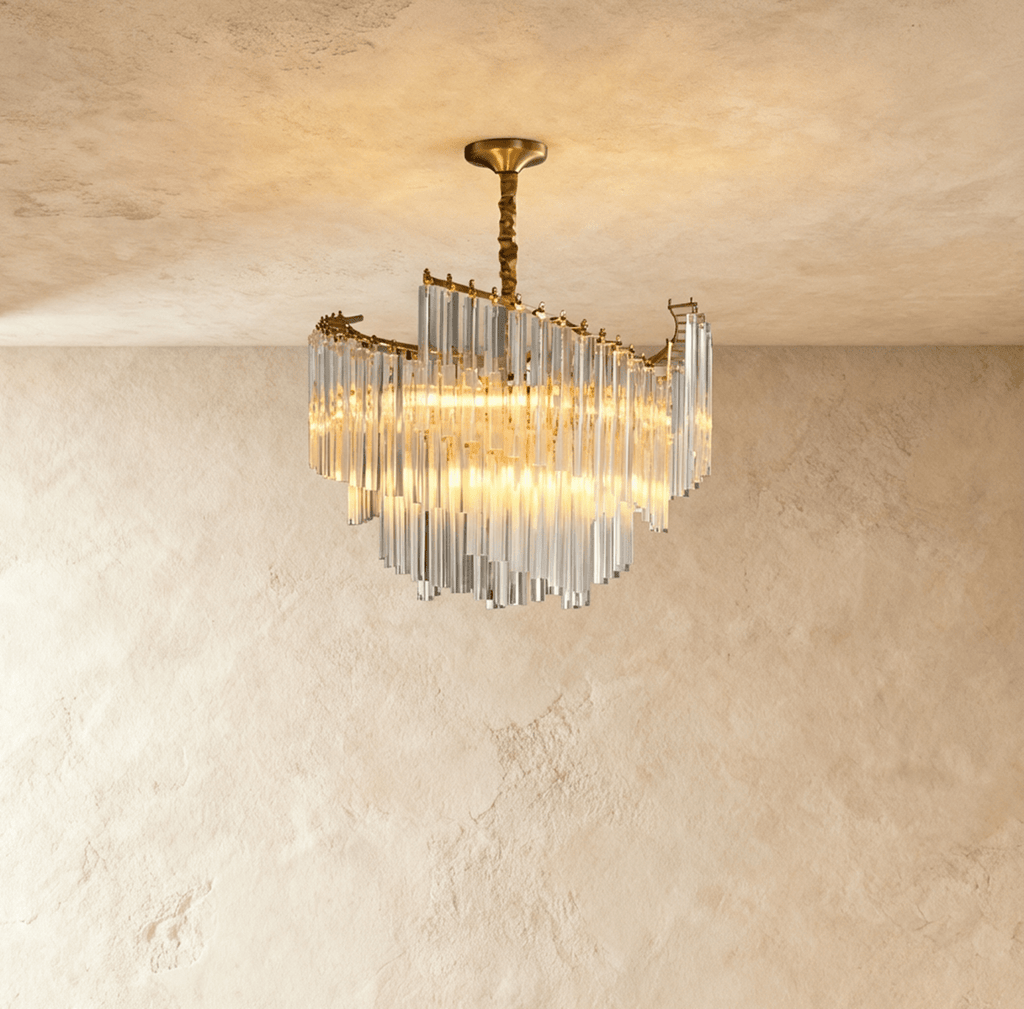 Clérachic compact tiered crystal-rod chandelier lit warm, hung from a gold canopy and twisted stem against limewash.
