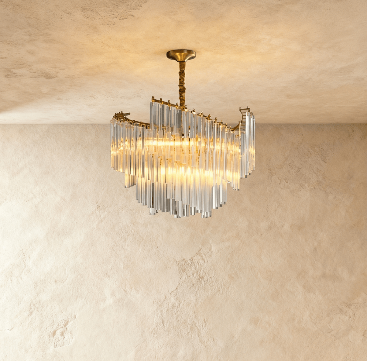 Clérachic compact tiered crystal-rod chandelier lit warm, hung from a gold canopy and twisted stem against limewash.