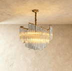 Clérachic crystal-rod chandelier in warm light, its swept tiers of clear glass hanging from a gold canopy and stem.