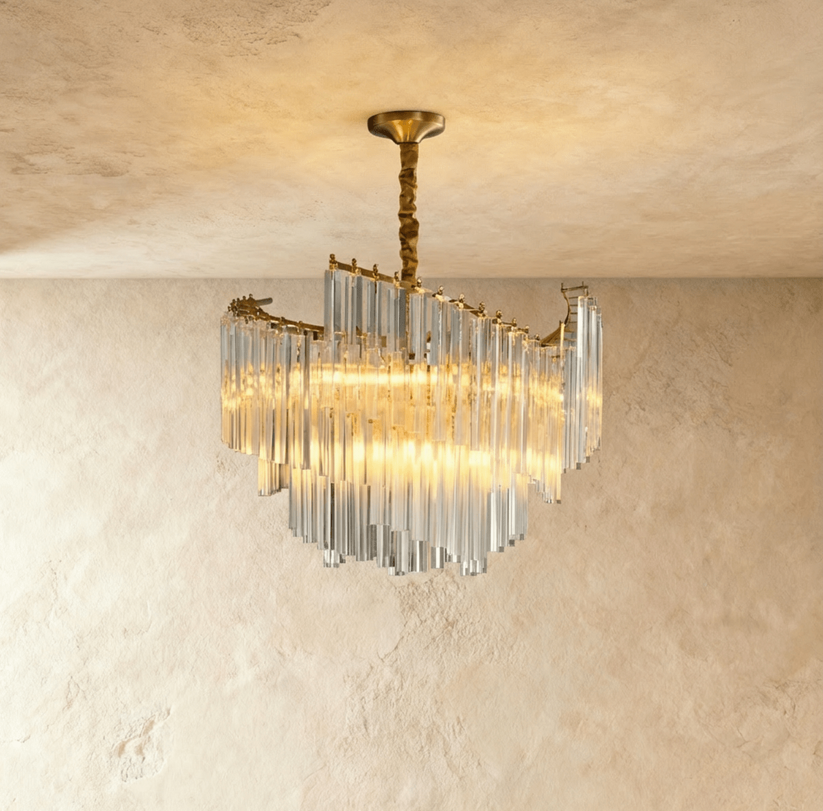 Clérachic crystal-rod chandelier in warm light, its swept tiers of clear glass hanging from a gold canopy and stem.