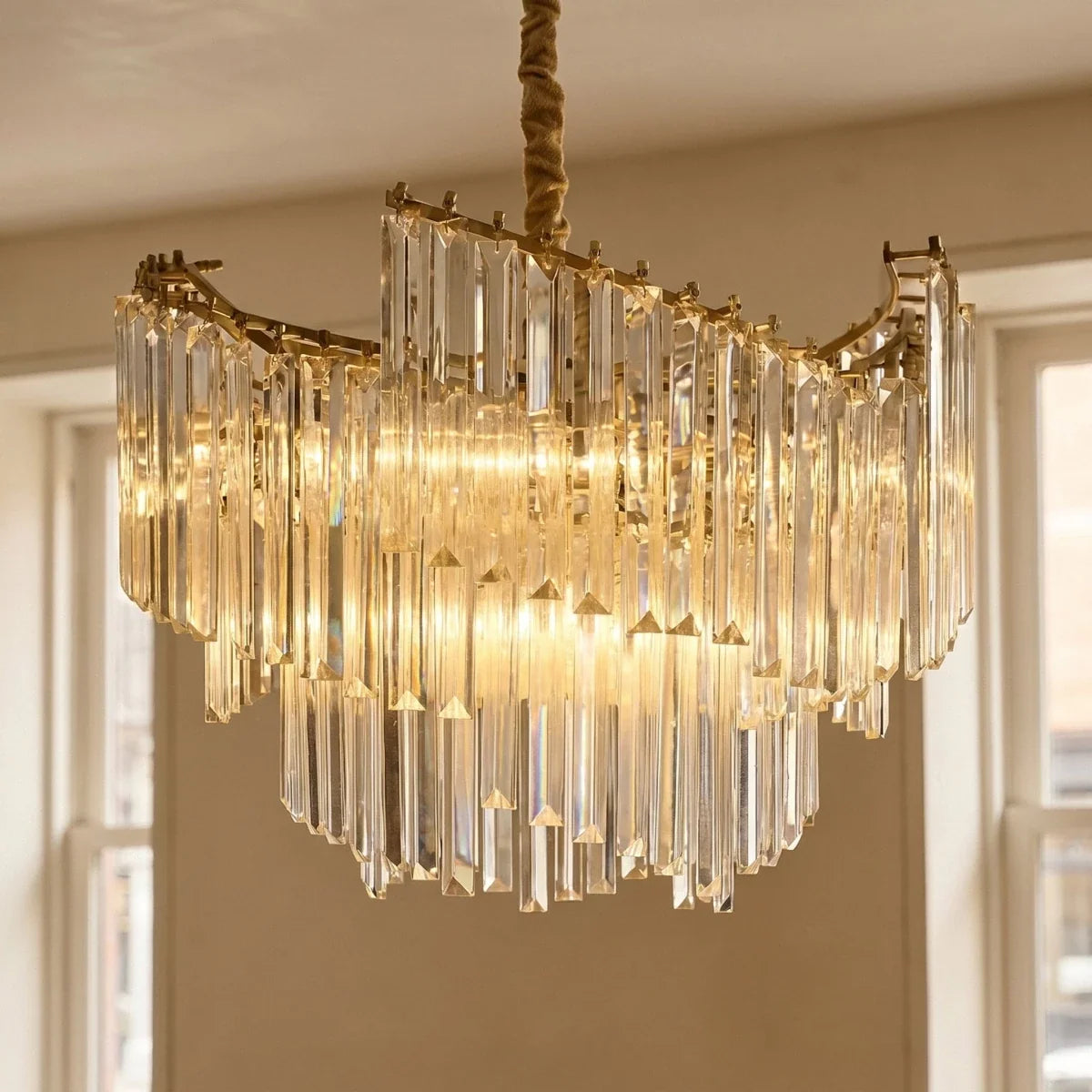 Clérachic close view of the crystal-rod chandelier, clear glass rods hung in layered tiers from a gold-toned frame.