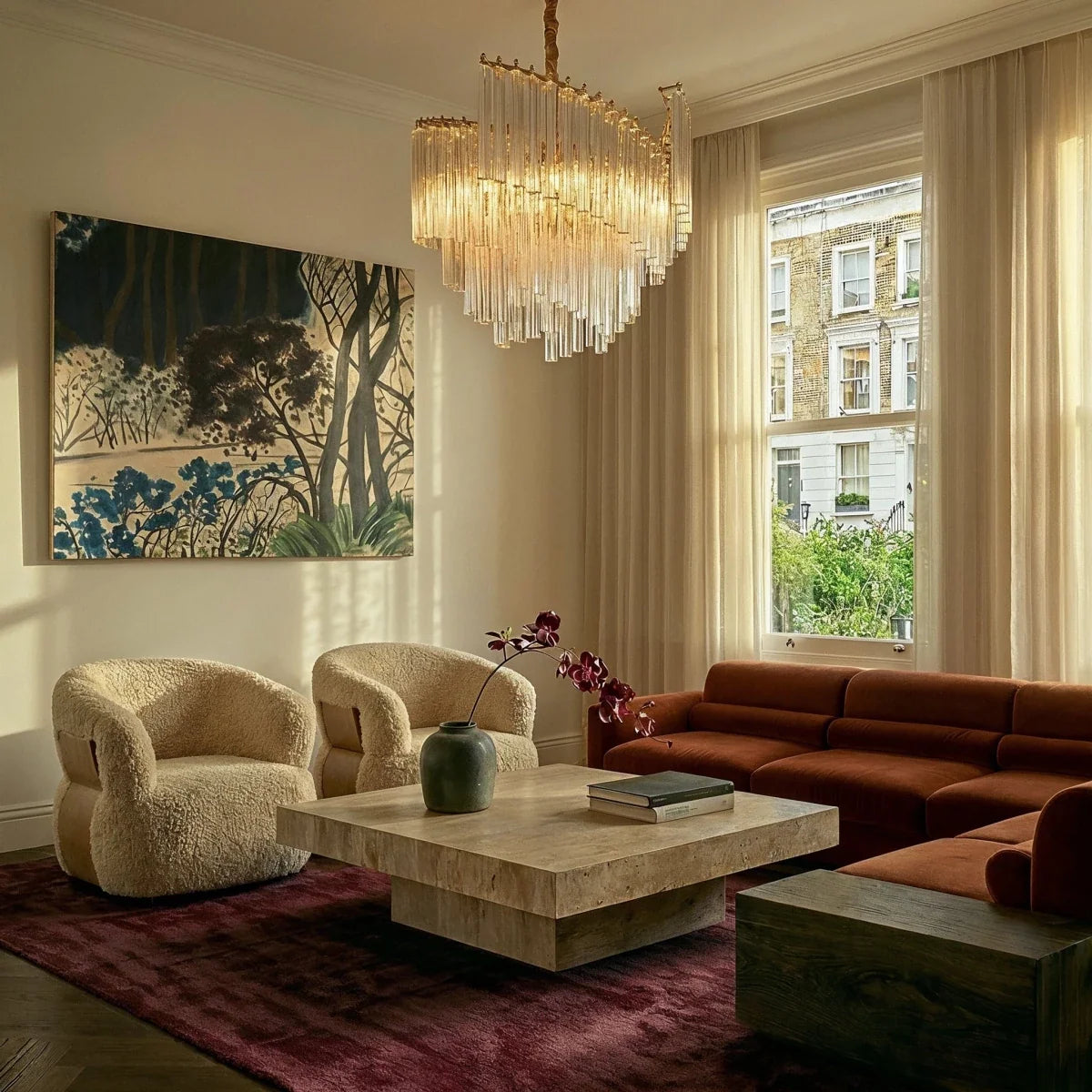 Clérachic crystal-rod chandelier in a bright sitting room with a travertine coffee table, boucle chairs and a rust velvet sofa.
