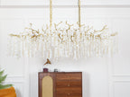 Clérachic branch chandelier switched off, its brass frame and trailing crystal strands hung above a sideboard with a record player.