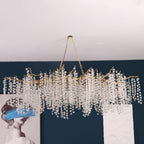 Looking up at a Clérachic chandelier hung from two chains in a room with a teal wall and a white ceiling.