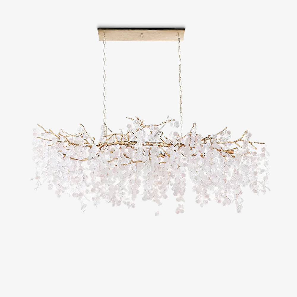 Clérachic long chandelier on a white backdrop, hung from a slim canopy plate, with a brass branch frame and pale crystal discs.