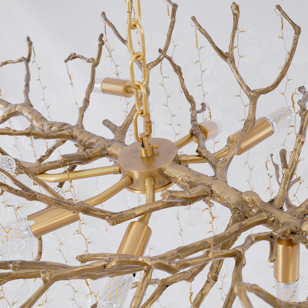 Underside view of the brass chain, ceiling plate and candle-style bulb holders at the centre of this Clérachic chandelier.