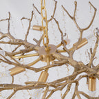 Underside view of the brass chain, ceiling plate and candle-style bulb holders at the centre of this Clérachic chandelier.