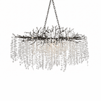 A long Clérachic chandelier in black, with a black branch frame and chains, and frosted crystal discs hanging below.