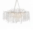 Clérachic long chandelier with silver-toned branches and a pale chain on a white backdrop, lit from within.