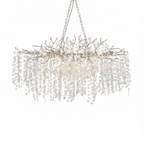 The long Clérachic chandelier on a white backdrop, shown with a pale silver frame, chains and frosted crystal discs.