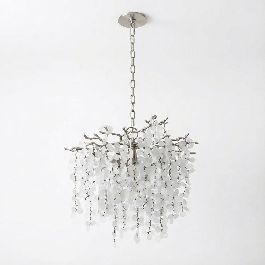 A round Clérachic chandelier with a nickel finish, a chain and a round ceiling plate, on a white backdrop.