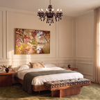 A Clérachic chandelier in black glass hangs above a bed, framed by a warm painted bedroom.