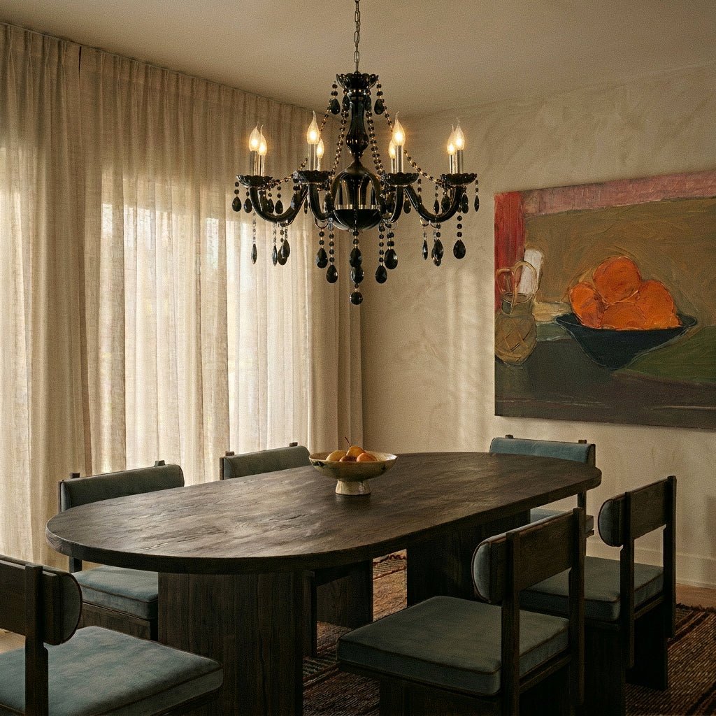 A Clérachic chandelier in black glass lights an oval dark-wood dining table beneath sheer curtains and a still-life painting.