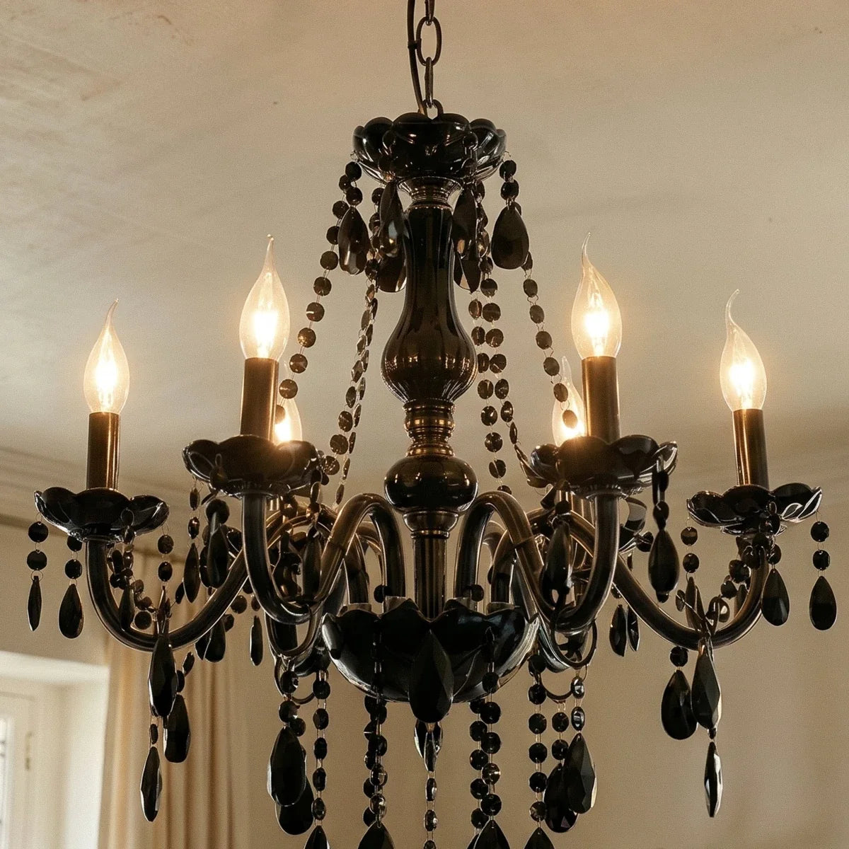 A close angle on the Clérachic chandelier's six lit candle arms and smoked glass column, set against a plaster ceiling.