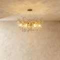 Clérachic gold branch-form crystal chandelier with clustered leaf-cut crystals, hung from a round ceiling canopy.