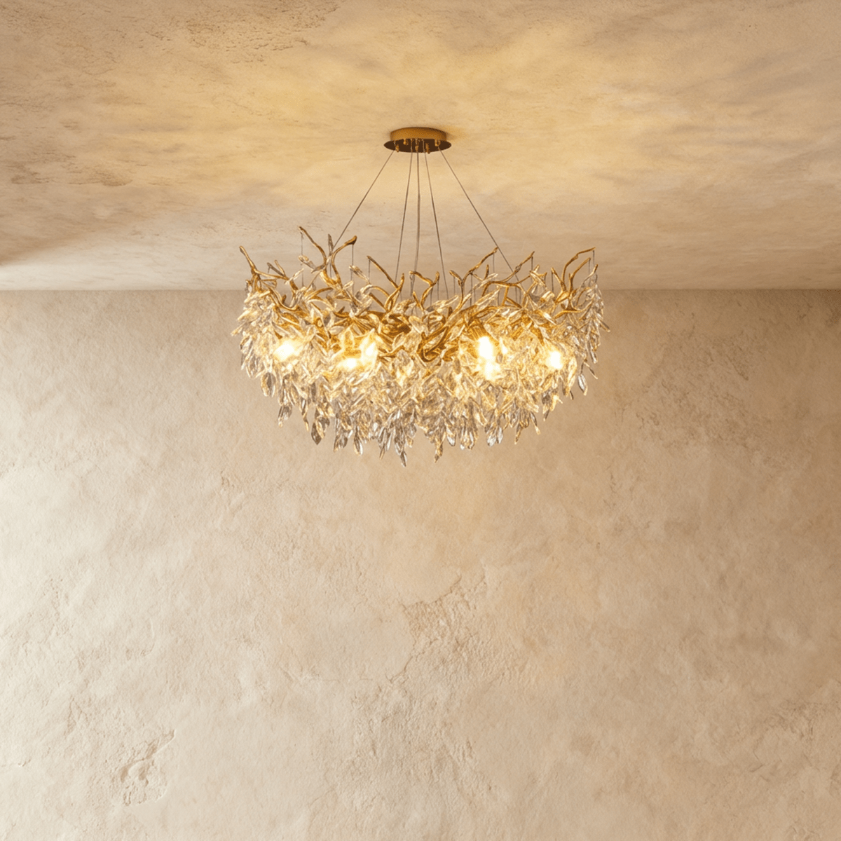 Clérachic gold branch-form crystal chandelier with clustered leaf-cut crystals, hung from a round ceiling canopy.