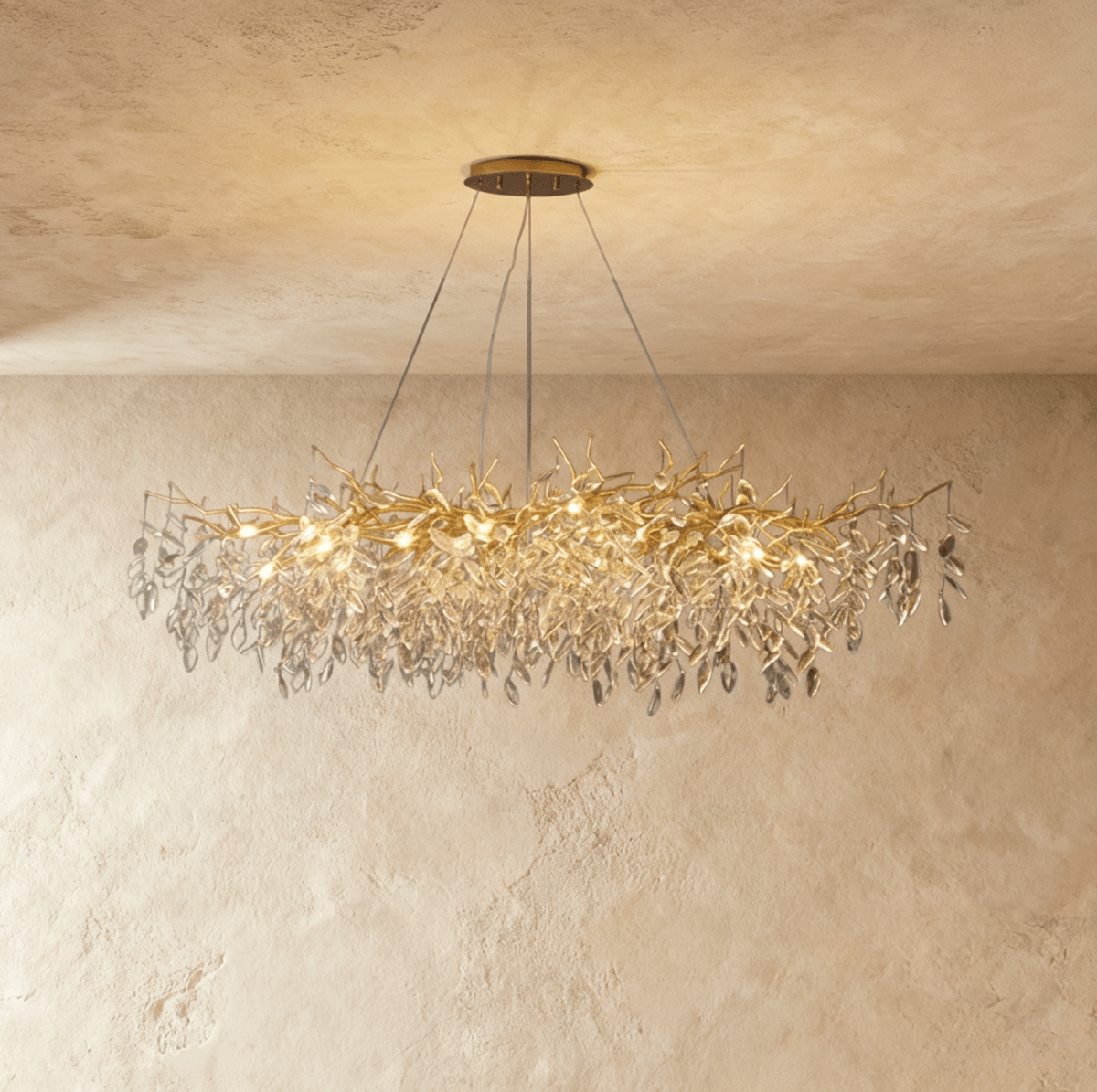 Clérachic oval gold branch chandelier glowing warm, cut crystal leaves trailing along its full width.
