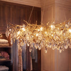 Clérachic chandelier detail, gold branch arms hung with crystal drops glowing warm inside a wood-panelled closet.