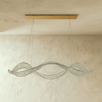 Clérachic crystal ribbon chandelier with a brushed gold ceiling plate, its strands of crystals twisting in waves beneath the ceiling.
