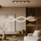Clérachic crystal ribbon chandelier glowing above a low round table in a calm living room with oak shelving and a cream sofa.