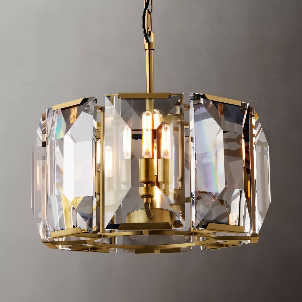 Clérachic drum chandelier in brass-toned metal with clear bevelled crystal panes and warm filament bulbs, shot on a grey backdrop.