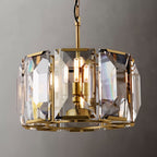 Clérachic drum chandelier in brass-toned metal with clear bevelled crystal panes and warm filament bulbs, shot on a grey backdrop.