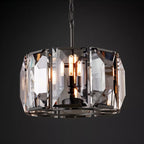 Clérachic black-framed crystal drum chandelier glowing warm against a dark charcoal backdrop, bulbs visible through the panes.