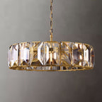 Clérachic wide ring chandelier with brass chain and frame, clear faceted crystal panes catching warm light on a grey backdrop.