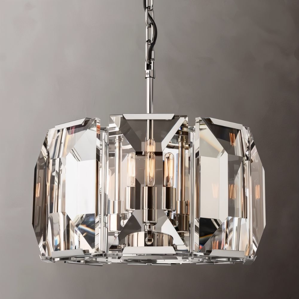 Clérachic polished steel drum chandelier with clear bevelled crystal panes, three filament bulbs inside, on a mid-grey backdrop.