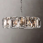 Clérachic large ring chandelier in polished steel with faceted crystal panes and a steel chain, set on a grey backdrop.